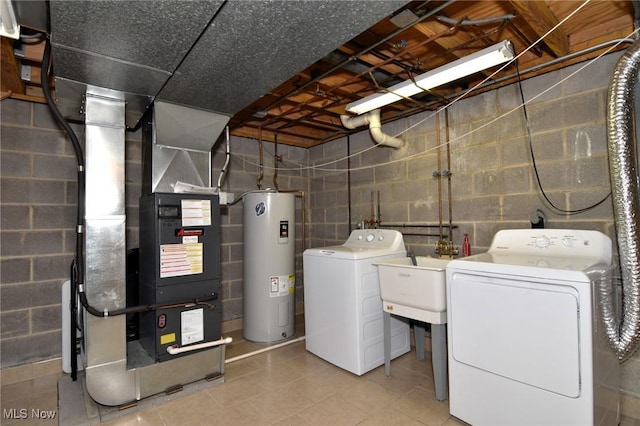 washroom featuring washing machine and clothes dryer, laundry area, concrete block wall, water heater, and heating unit