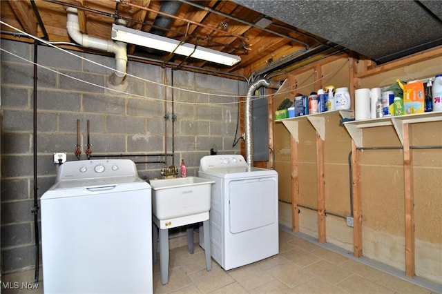 clothes washing area featuring laundry area, independent washer and dryer, tile patterned flooring, concrete block wall, and a sink