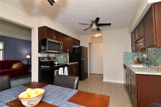 kitchen featuring a ceiling fan, a sink, appliances with stainless steel finishes, and tasteful backsplash