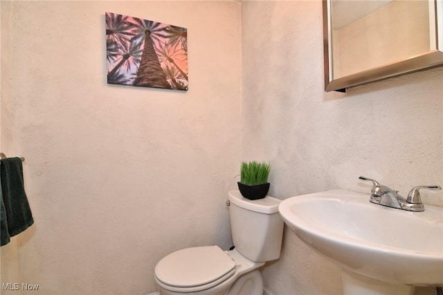 half bathroom with a sink and toilet