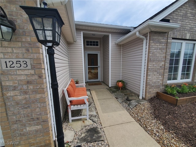 view of exterior entry featuring brick siding