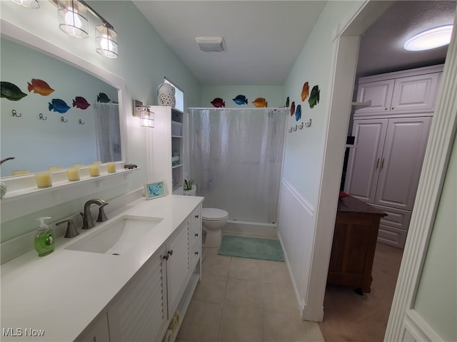 full bath featuring vanity, tile patterned floors, toilet, and a shower stall