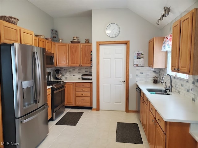 kitchen with light countertops, appliances with stainless steel finishes, decorative backsplash, and a sink