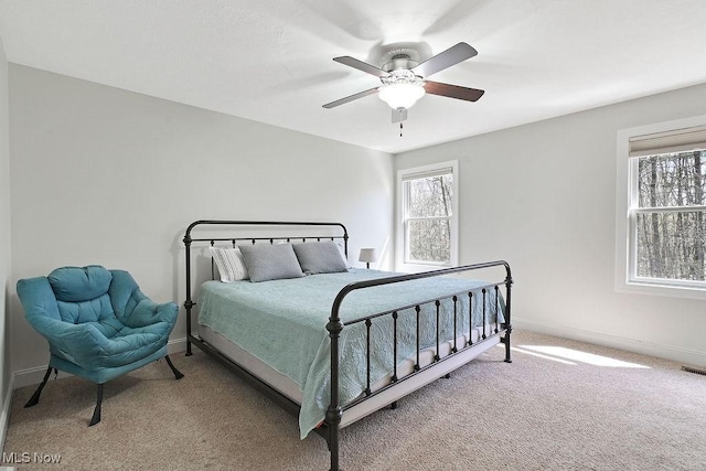 carpeted bedroom with baseboards and ceiling fan