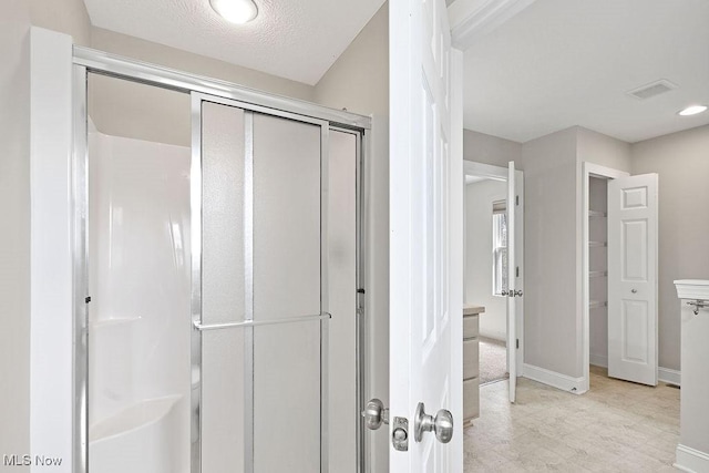 bathroom featuring baseboards, recessed lighting, a stall shower, and visible vents