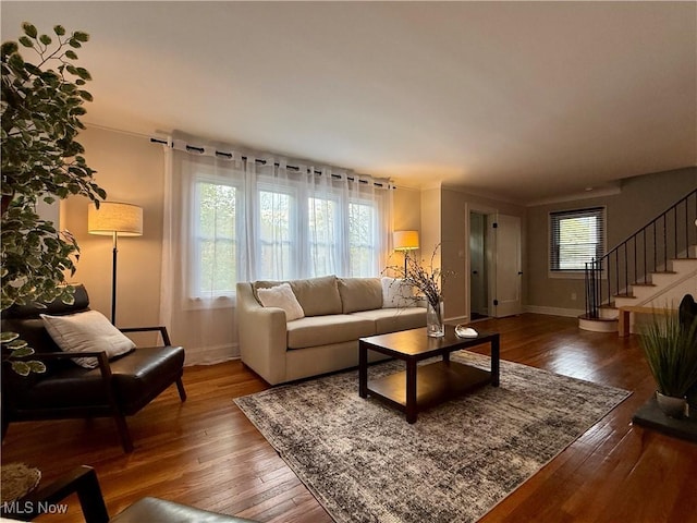 living area with stairs, baseboards, and hardwood / wood-style flooring