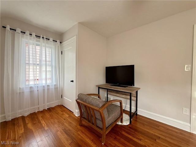living area with baseboards and hardwood / wood-style flooring