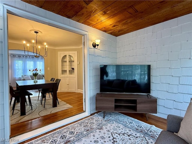 living area featuring an inviting chandelier, wood ceiling, and wood finished floors