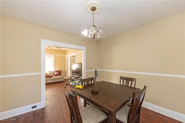 1459 W 107th St, Cleveland, OH 44102 - dining room with a textured ceiling, baseboards, a chandelier, and wood finished floors