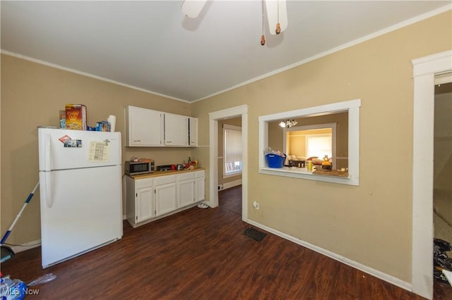 1459 W 107th St, Cleveland, OH 44102 - kitchen with freestanding refrigerator, white cabinetry, stainless steel microwave, dark wood-type flooring, and visible vents