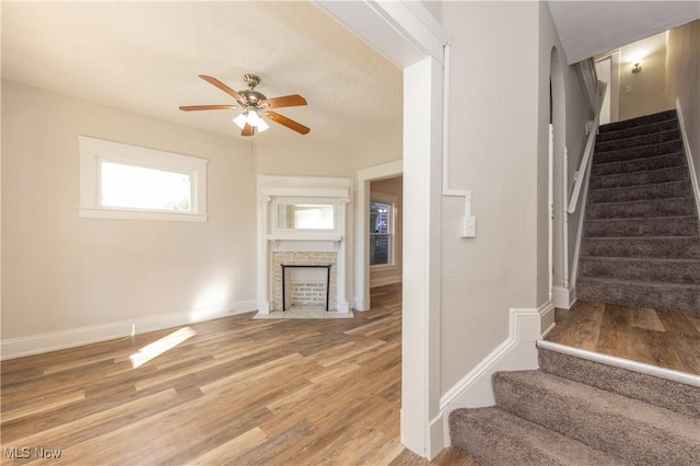 1459 W 107th St, Cleveland, OH 44102 - stairs featuring baseboards, a ceiling fan, a fireplace with flush hearth, and wood finished floors