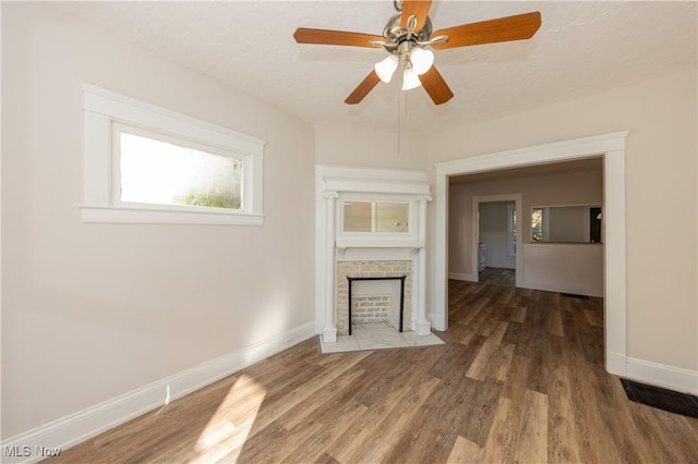 1459 W 107th St, Cleveland, OH 44102 - unfurnished living room with baseboards, a fireplace with flush hearth, a wealth of natural light, and wood finished floors