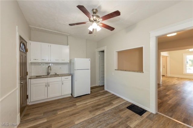 1459 W 107th St, Cleveland, OH 44102 - kitchen featuring visible vents, freestanding refrigerator, dark wood-style floors, white cabinets, and a sink