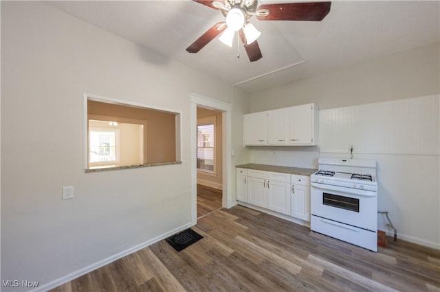 1459 W 107th St, Cleveland, OH 44102 - kitchen with white cabinets, baseboards, dark wood finished floors, and gas range gas stove