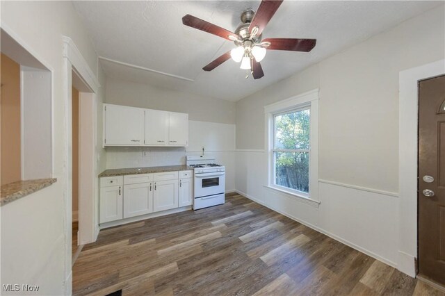 1459 W 107th St, Cleveland, OH 44102 - kitchen with a ceiling fan, dark wood finished floors, baseboards, white range with gas cooktop, and white cabinetry