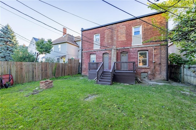 1459 W 107th St, Cleveland, OH 44102 - back of house featuring a fenced backyard, a yard, and brick siding