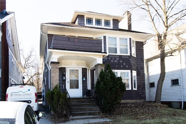 view of front of home featuring a balcony and a chimney