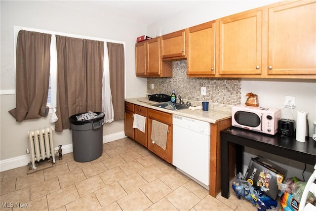 kitchen featuring a sink, white appliances, radiator, baseboards, and decorative backsplash