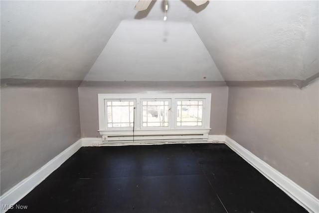 additional living space with a ceiling fan, baseboards, vaulted ceiling, and baseboard heating