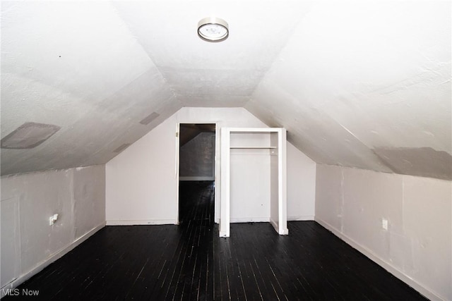bonus room featuring baseboards, lofted ceiling, and hardwood / wood-style floors