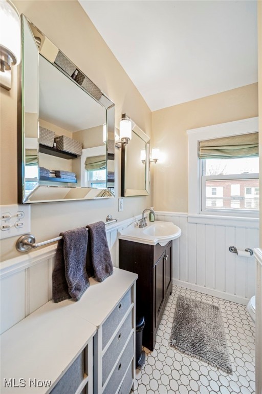 bathroom with toilet, wainscoting, and vanity