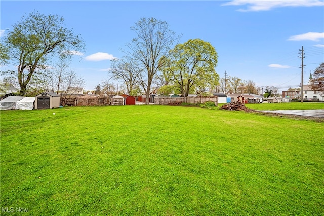 view of yard with a shed, an outbuilding, and fence