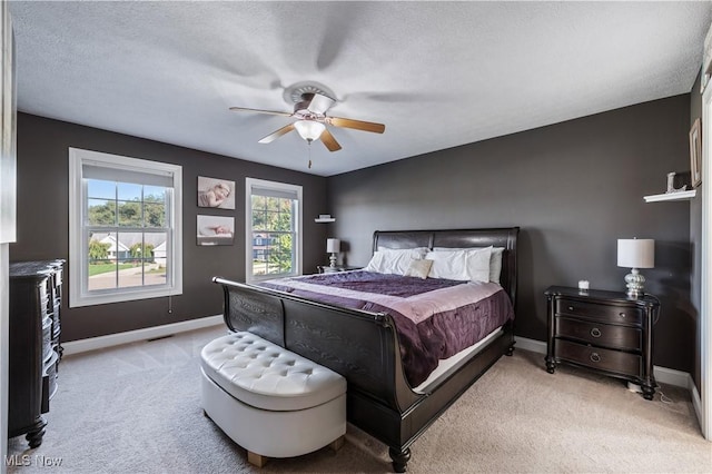 bedroom featuring carpet floors, a ceiling fan, baseboards, and a textured ceiling