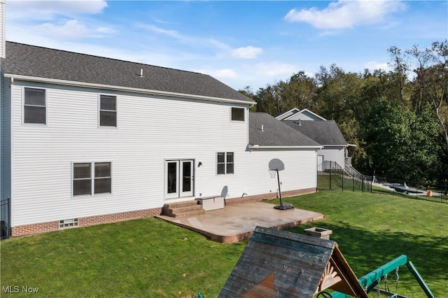 back of property featuring fence, a shingled roof, entry steps, a patio area, and a lawn
