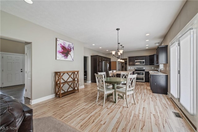 dining area featuring recessed lighting, baseboards, light wood-type flooring, and a notable chandelier