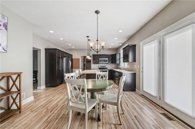 dining space featuring visible vents, an inviting chandelier, light wood-style floors, baseboards, and recessed lighting