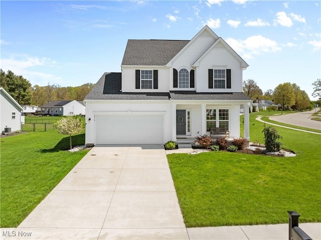 870 Thewes Cir, Louisville, OH 44641 - traditional-style house with a front lawn, covered porch, roof with shingles, concrete driveway, and an attached garage