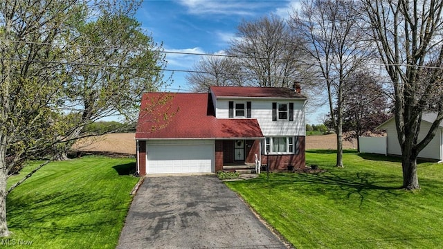 view of front of house featuring an attached garage, a front lawn, brick siding, and aphalt driveway