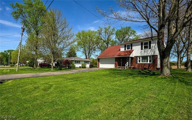 traditional-style home featuring brick siding, a garage, driveway, and a front yard