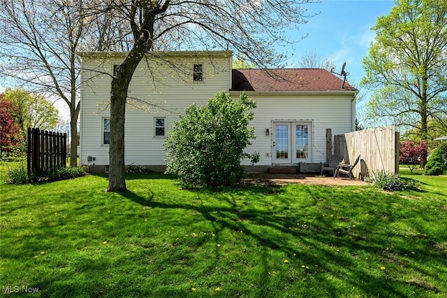 back of property with fence and a yard