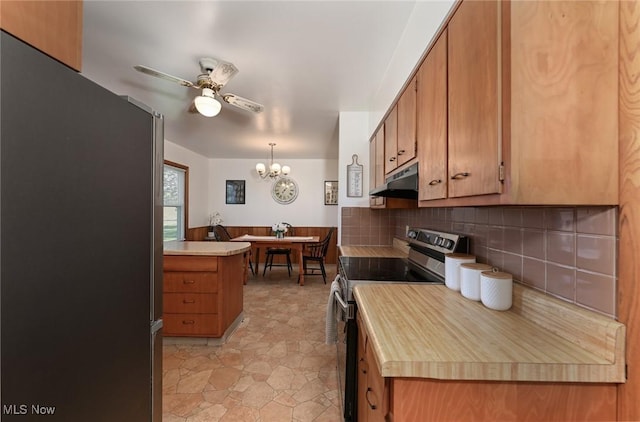 kitchen with stainless steel appliances, brown cabinets, and under cabinet range hood