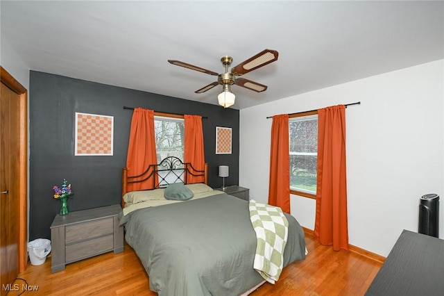 bedroom featuring baseboards, ceiling fan, and wood finished floors