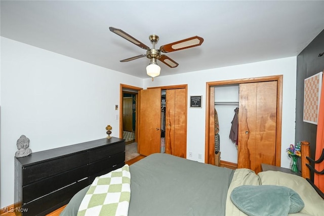 bedroom with a ceiling fan and two closets