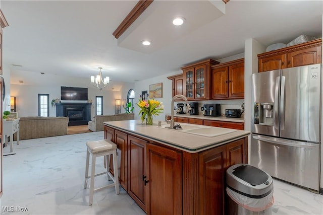 kitchen with an inviting chandelier, marble finish floor, glass insert cabinets, light countertops, and stainless steel fridge with ice dispenser