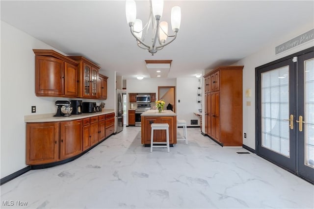kitchen with brown cabinetry, french doors, appliances with stainless steel finishes, light countertops, and an inviting chandelier