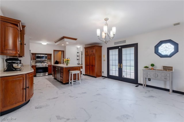 kitchen with french doors, light countertops, marble finish floor, an inviting chandelier, and stainless steel appliances