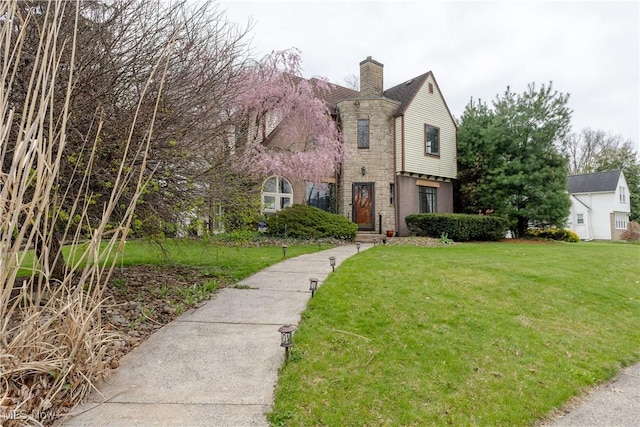 view of front of house with a chimney and a front yard
