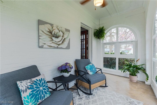 sunroom / solarium featuring a ceiling fan