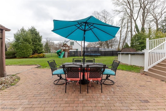view of patio featuring a fenced backyard, a trampoline, a playground, and outdoor dining space