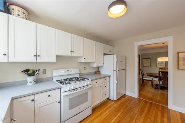 2155 Middlefield Rd, Cleveland Heights, OH 44106 - kitchen featuring decorative light fixtures, light countertops, light wood finished floors, white appliances, and white cabinetry