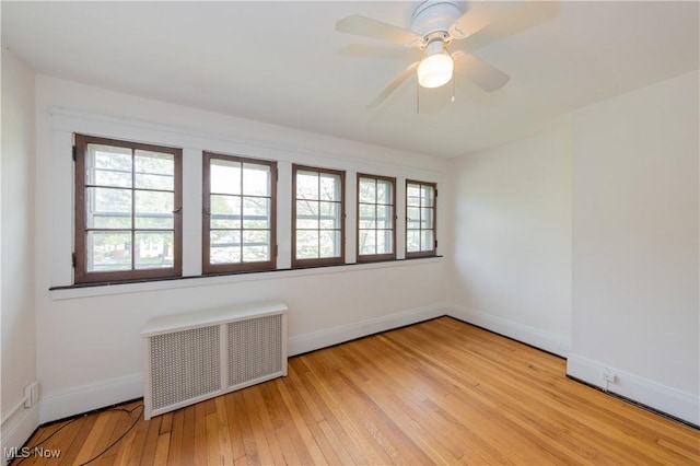 2155 Middlefield Rd, Cleveland Heights, OH 44106 - spare room featuring baseboards, a wealth of natural light, radiator heating unit, and hardwood / wood-style floors