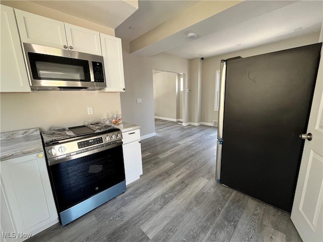 10402 Almira Ave, Cleveland, OH 44111 - kitchen featuring light countertops, stainless steel appliances, dark wood-style floors, and white cabinetry