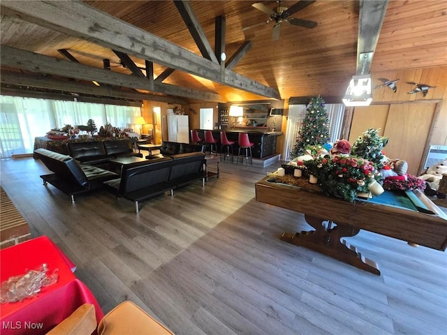 5294 Cottage Dr, Mecca, OH 44410 - living area with wood walls, wood finished floors, vaulted ceiling with beams, wooden ceiling, and a ceiling fan