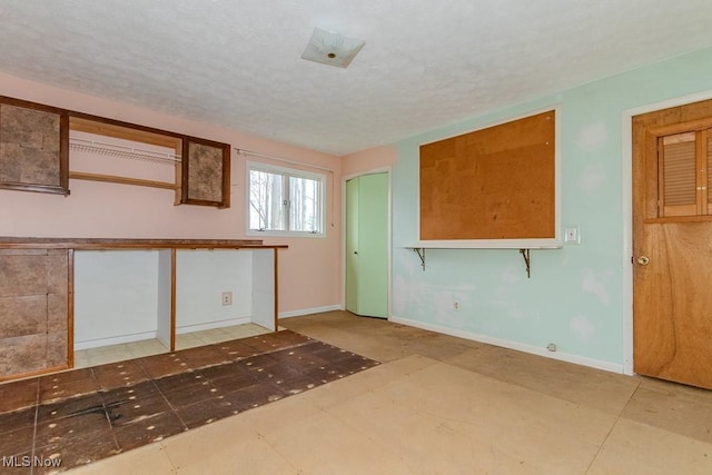 interior space with baseboards and a textured ceiling