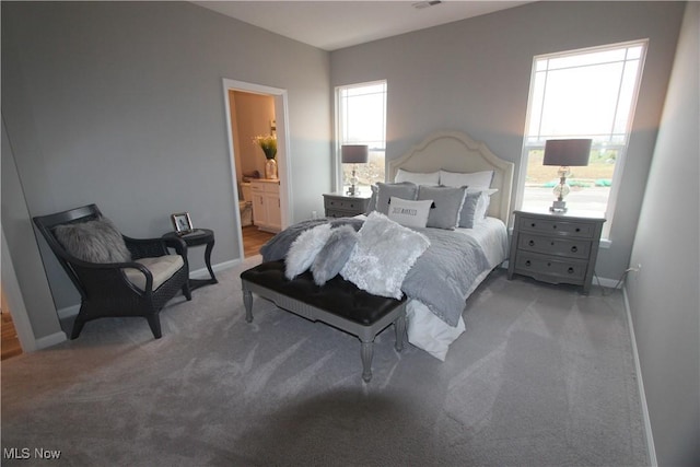 bedroom featuring baseboards, ensuite bathroom, carpet, and visible vents