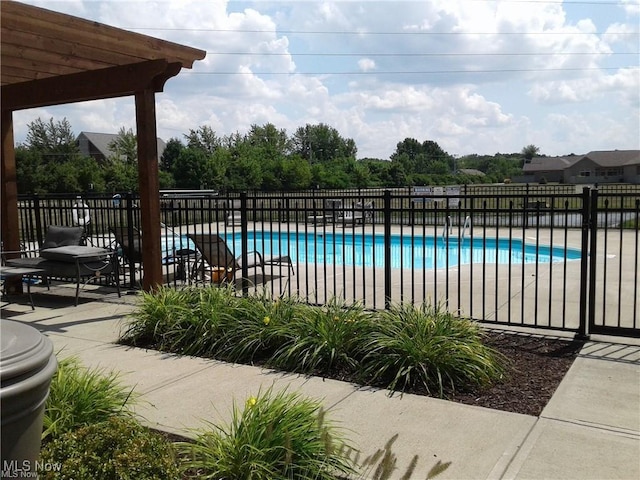 community pool featuring fence and a patio area